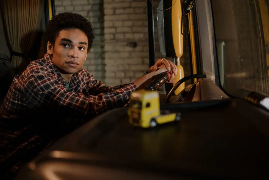 A driver seated in a truck cab, illustrative of behind-the-wheel entry-level driver training